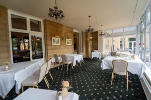 a dining room with white tables and chairs at Grinkle Park Hotel in Loftus