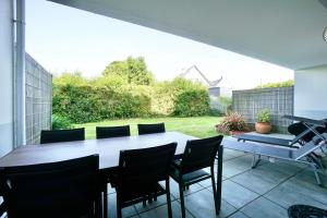 a patio with a table and chairs on a patio at L'Amirage * à 200m de la mer* in Ploemeur +19 photos