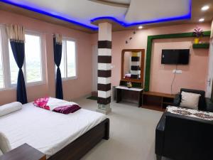 a bedroom with a bed and a tv in it at Dooars View Hotel in Hāsimāra +4 photos