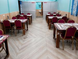 a conference room with tables and chairs with red chairs at Dooars View Hotel in Hāsimāra