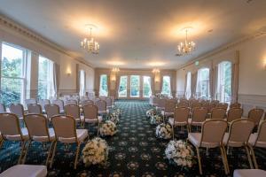 a room with chairs and tables and chandeliers at Grinkle Park Hotel in Loftus