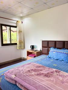 a bedroom with a large bed and a window at บ้านพักสมพงศ์ภูทับเบิก in Ban Maeo Thap Boek