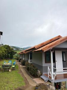 a house with a table and a picnic table in the yard at บ้านพักสมพงศ์ภูทับเบิก in Ban Maeo Thap Boek