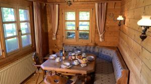 a dining room with a wooden table and two windows at Chalet Zugspitze in Grainau