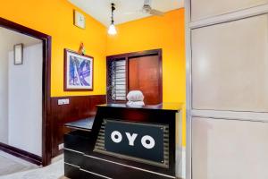 a tv in a room with a yellow wall at Hotel O Le Regent in Gurgaon +31 photos