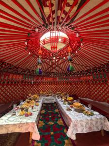 a table with plates of food in a red room at Guest House Nuraiym in Bokonbayevo