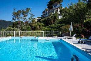 a swimming pool with blue water in front of a fence at Moneglia - Le Case di Bart in Moneglia