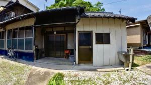 a small house with a porch and a bike parked outside at 陽だまりハウス in Hiroshima