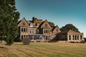 a large house with a large grassy field in front of it at Grinkle Park Hotel in Loftus
