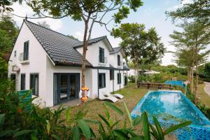 an exterior view of a house with a swimming pool at Daisy Queen Village Ba Vì in Yên Cư