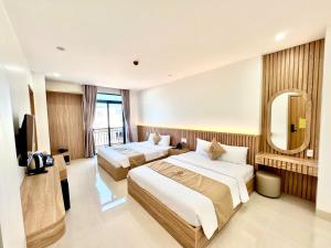a hotel room with two beds and a mirror at Khách Sạn Anh Khoa 2 in Phan Rang–Tháp Chàm