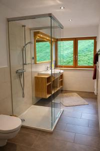 a bathroom with a glass shower and a sink at Chalet Leni in Schladming