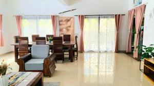 a dining room with a table and chairs and windows at Villa Tsara Nosy be in Nosy Be