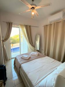 a bedroom with a bed with a ceiling fan and a window at Seana Hidden Gem in Kapparis in Paralimni