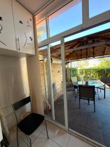 a patio with a table and chairs and glass doors at Seana Hidden Gem in Kapparis in Paralimni