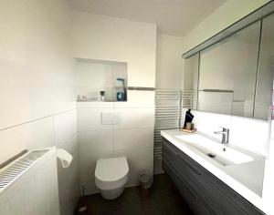 a white bathroom with a toilet and a sink at Ferienwohnung Schöne Aussicht in Nieheim