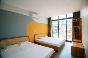 a hotel room with two beds and a window at Daisy Queen Village Ba Vì in Yên Cư +113 photos