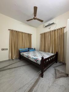 a bedroom with a bed and a ceiling fan at Stay at Renovated Home at DBRA-61 Don Bosco Cross Road Vaduthala Ernakulam in Cochin