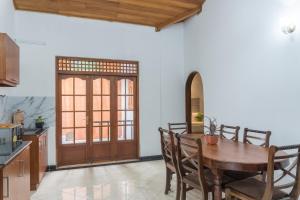 a kitchen and dining room with a wooden table and chairs at Ditara in Katugastota +12 photos