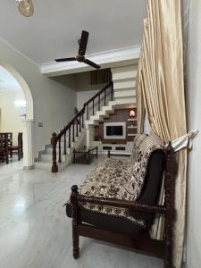 a living room with a couch and a staircase at Stay at Renovated Home at DBRA-61 Don Bosco Cross Road Vaduthala Ernakulam in Cochin