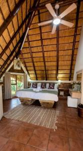 a bedroom with a bed and a ceiling fan at Selukwe Safari Lodge in Marloth Park