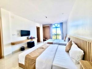 a large bedroom with two beds and a television at Khách Sạn Anh Khoa 2 in Phan Rang–Tháp Chàm