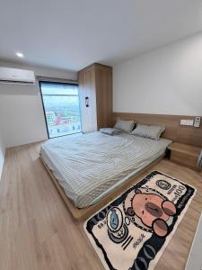 a bedroom with a large bed and a large window at Ong Vàng in Quang Ãm