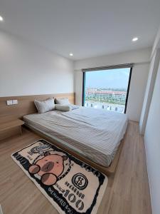 a bedroom with a bed with a large window at Ong Vàng in Quang Ãm
