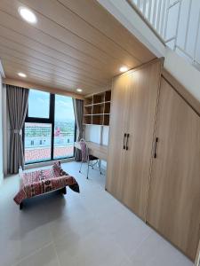 a bedroom with a bed and a desk and a window at Ong Vàng in Quang Ãm