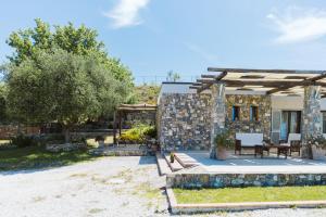 a stone house with a table and chairs in a yard at Villa Serra d'Elci in Ascea