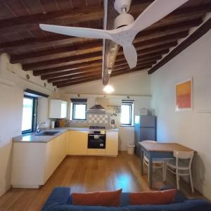 a kitchen with a ceiling fan and a table at Studio in Tuscan farmhouse with pool in Monteguidi