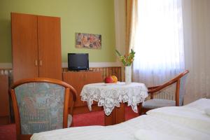 ein Zimmer mit 2 Betten und einem Tisch mit einem Apfel darauf in der Unterkunft Hotel Central in Bad Elster