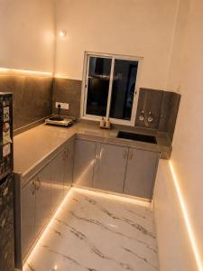 a kitchen with a counter with a sink and a window at Vibhor peace cottage in Chitrakoot