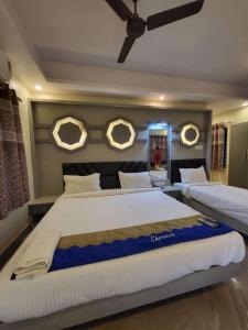 a bedroom with two beds and two mirrors on the wall at Hotel Shreesh Mayapur in mayapur