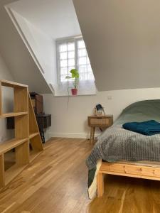 a bedroom with a bed and a window at Charmant petit maison in Pontorson