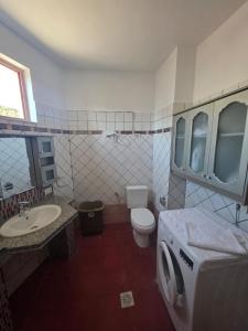 a bathroom with a washer and a toilet and a sink at Comfort Saranda Apartment in Sarandë +13 photos