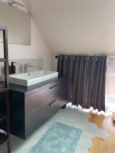 a bathroom with a sink and a shower curtain at Charmant petit maison in Pontorson +14 photos