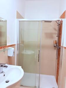 a shower with a glass door next to a sink at RBS Hotel, Rochester in Rochester +11 photos