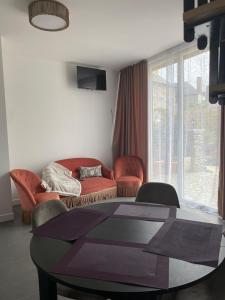 a living room with a couch and chairs and a table at Charmant petit maison in Pontorson