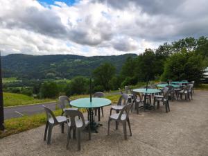 a row of tables and chairs with mountains in the background at Gite la Borie de Pourtou Santoire in Condat