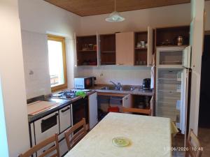 a kitchen with a table and a stove top oven at Casa Bezzi in Pellizzano