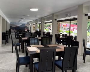 a dining room with tables and chairs and windows at Kamchia Park Hotel - All Inclusive in Golden Sands