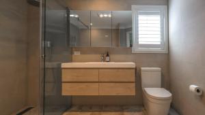 a bathroom with a toilet and a sink and a shower at Handleys Cottage in High Range +12 photos