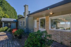 a brick house with a window and a yard at Handleys Cottage in High Range