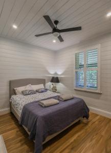 a bedroom with a bed with a ceiling fan at Handleys Cottage in High Range