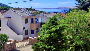 a white house with a view of the ocean at Apartmani Anastazija in Karlobag