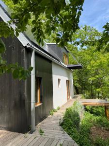 a black and white house with a wooden deck at Studio MEZILES in Buš +25 photos