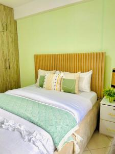 a bedroom with a large bed with pillows on it at Bethany Cushy Home Ltd in Kisii