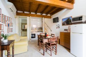 a kitchen and living room with a table and a refrigerator at Tre Volte Belle - Salento Selection in Carpignano Salentino +38 photos