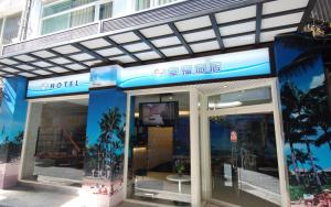 un edificio de hotel con un cartel en la parte delantera en Happiness Inn, en Taipéi